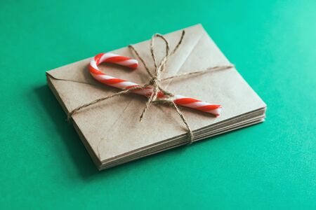 Craft paper envelopes tied with string and decorated with Christmas candy. Envelopes made of Kraft...