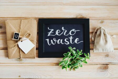 Lettering poster zero waste and Kraft envelopes with tag. Package, and chalk inscription zero waste. Green sprig Aptenia.の写真素材