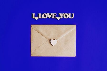 Kraft the envelope for the letter. The letter is a love letter. Valentine's Day. February 14. Wooden figures. I love you. The background colors of the year 2020 are classic blue.の写真素材