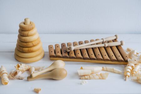 Wooden xylophone, maracas and pyramid. Toys for children, made by hand from natural wood. Wooden shavings.の写真素材