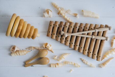 Wooden xylophone, maracas and pyramid. Toys for children, made by hand from natural wood. Wooden shavings.の写真素材