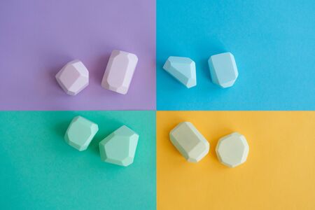 Wooden stones. Children's game. Colorful wooden figurines. A bright background of four colors.