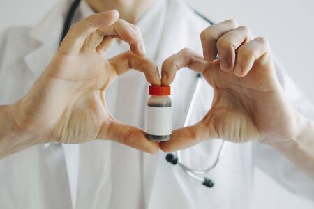 The doctor is holding a tube of medicine in his hand. Vaccine against the virus. Vaccine Covid-19....
