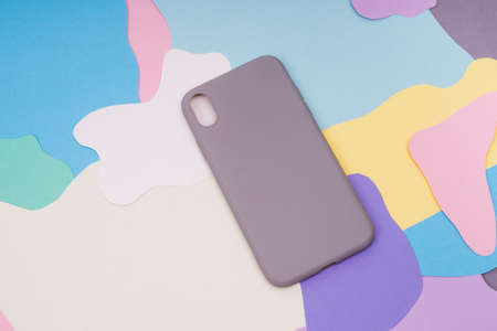 The gray silicone case for the smartphone lies on a multi-colored background. Protect your phone.の写真素材