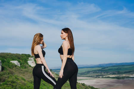 Girls play sports in the mountains. Sport on the pro-prod. Fitness in the woods. Yoga in nature.の写真素材