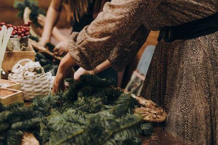 Woman making christmas wreath. A master class on creating a Christmas wreath from a natural spruce with your own hands. A Christmas wreath made with your own hands.の写真素材