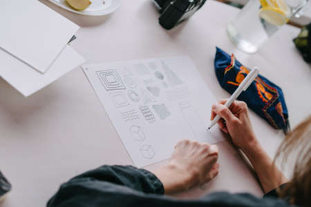 The drawing process. The girl draws a linener. Different patterns on white paper. Master class in...