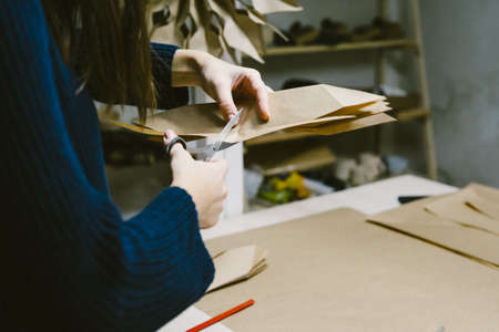 Cut a craft paper crafting. The origami stage. Creating hand made christmas ornaments. DIY personalized xmas decoration. Snowflake or three-dimensional star made of kraft paper. Step by step instructions.の写真素材