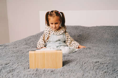 A little girl is talking very emotionally over a video link. Distance learning via video communication.の写真素材