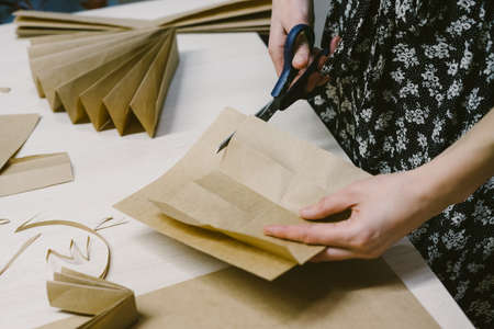 The origami stage. DIY personalized xmas decoration. Creating hand made christmas ornaments. Step by step instructions. Snowflake or three-dimensional star made of kraft paper.の写真素材