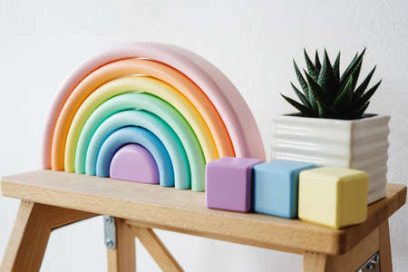 Interior decor for children's room in the form of a rainbow. Environmentally friendly toys for children. Wooden cubes and ceramic pot with succulent. Wooden rainbow made of natural wood.の写真素材