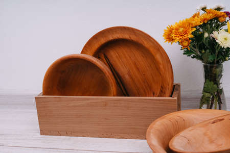 Plates made of natural material. Chrysanthemums autumn flowers.