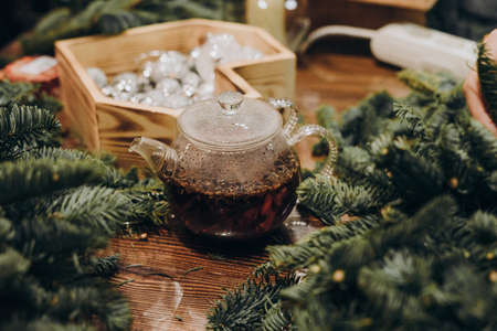 Creation of a Christmas wreath from natural fir and Christmas decorations. Master class on creating a Christmas wreath. made Decor with your own hands. Glass kettle with delicious brewed tea.の写真素材