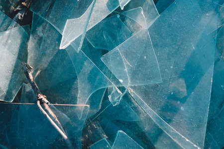 A broken window. Glass is scattered on the road.