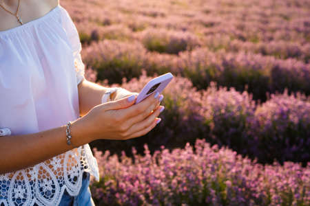 Girl in her hand holds a smartphone in a purple silicone case.の写真素材