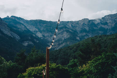 The festive garland adorns the event in the open area. Decor of events. Beautiful mountain landscape. Wedding, birthday, party, new year.の写真素材