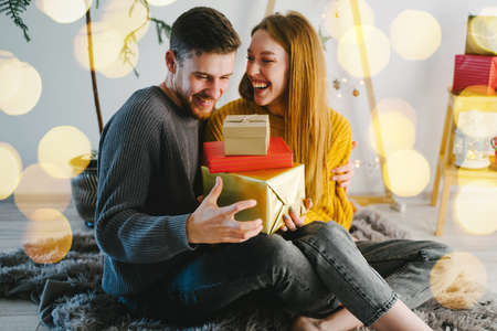 Couple in love is sitting in a Christmas location with a beautiful eco-friendly holiday decor....