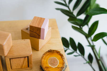 Wooden Montessori cubes. Eco-friendly toys for preschoolers. Toys made of natural material. No plastic toys. Wooden shelf with children's cubes. Multi-colored flags in the background.の写真素材