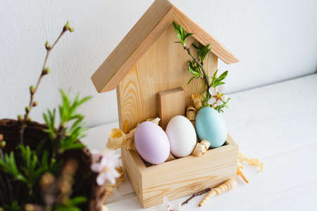 Happy Easter day. Easter decor. Painted eggs in a wooden house. Spring. Easter eggs.