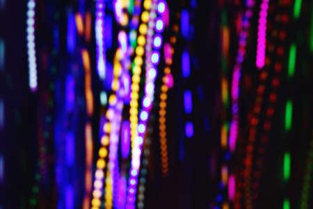 Festive background with bright neon bokeh. Selective focus. Blurry background. Light bulbs in defocus.の写真素材