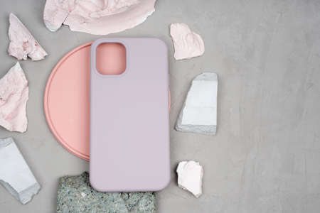 Pastel-colored silicone case for smartphone. Different stones by color, size and texture. Pink gypsum plate. Silicone protective case in beige color.の写真素材