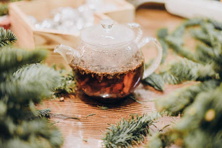Creation of a Christmas wreath from natural fir and Christmas decorations. Master class on creating a Christmas wreath. made Decor with your own hands. Glass kettle with delicious brewed tea.の写真素材