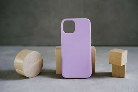 Lilac silicone case for smartphone on a gray textured background. Color concept - very peri color of...