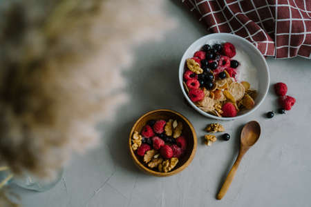 Healthy breakfast with berries. Multi-cereal flakes, natural yogurt, raspberries and black currants, walnuts. Tasty food.の写真素材