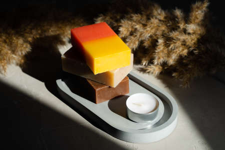 Handmade soap lies on a gray oval soap dish.