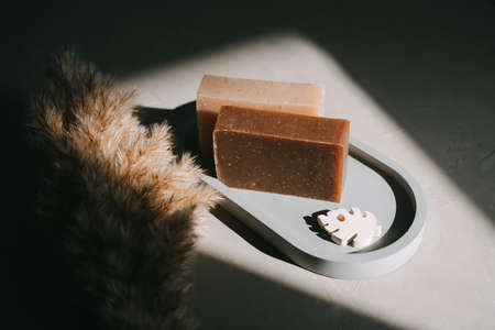 Handmade natural soap are lying on a gray oval tray.の写真素材