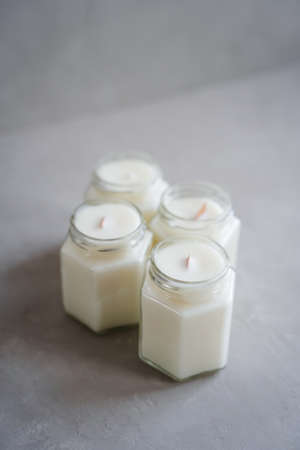 Set of candles made of natural soy wax in glass jars. Candles with wooden crackling wicks and cotton reinforced wicks. Scented candles in glass containers. Zero waste product. vertical photo.の写真素材