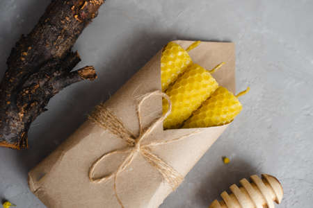 Set of honey candles in a craft envelope. Wooden stick for honey. A natural product.の写真素材