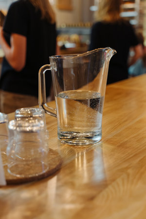 Interior of a cozy coffee shop. A decanter with drinking water on a wooden table.の写真素材