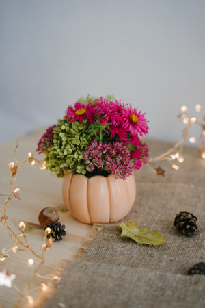 Autumn composition with a bouquet of flowers. Garland with warm light. Bokeh. Thanksgiving Day.の写真素材