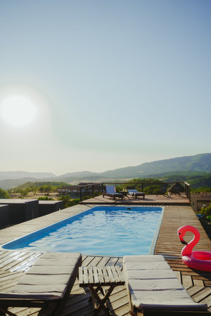 Swimming pool, sun loungers, swimming ring in the form of a pink flamingo.の写真素材