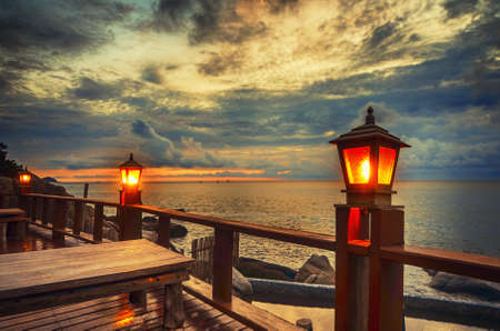 Wooden lamps along the seaside featuring awesome cloudy sunset skyの写真素材