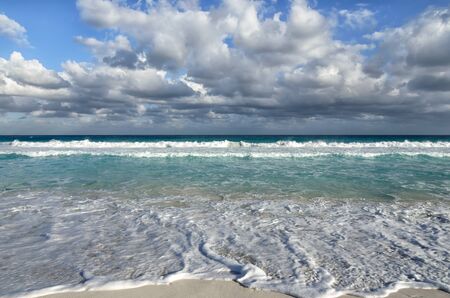 White foamy waves and gradually darkening color of sea water with stripe of white sandy beach - perfect travel backgroundの写真素材