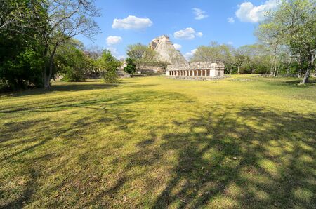 Stunning view to Mayan ruins and green grass field in front