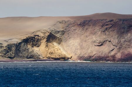 View to red and yellow rock formation at the coastの写真素材