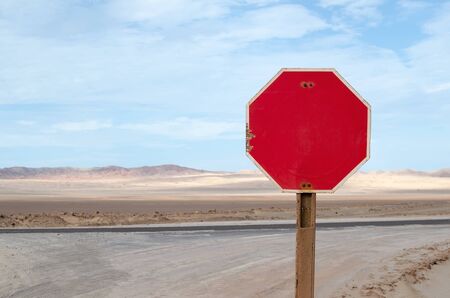 Red stop sign along the road in desertの写真素材