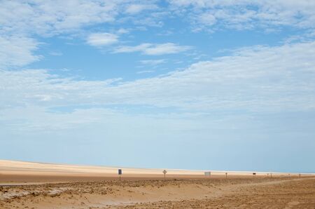 Road in desert with numerous road signs under blue skyの写真素材
