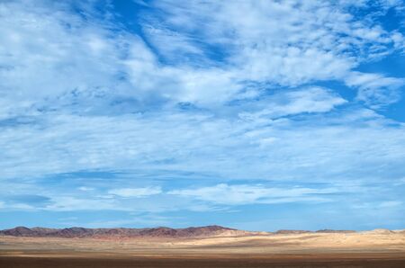 Desert under blue cloudy sky