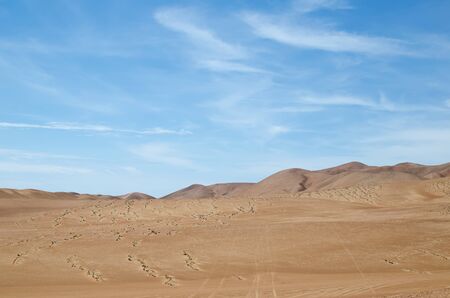 Sands of the desert under bright blue sky with few cloudsの写真素材