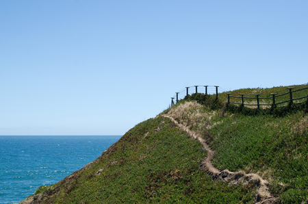 The edge - beautiful natural background of green hill and seaの写真素材