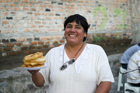 AREQUIPA, PERU, 01 FEBRUARY 2017: Peruvian street chef with plate of traditional food picaronesのeditorial素材