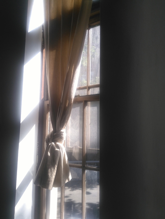 Morning light coming through window with beige curtainの写真素材