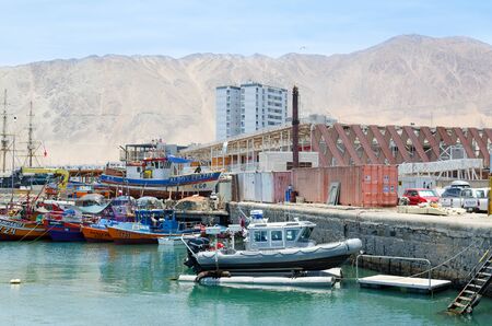 IQUIQUE, CHILE, 2017-01-18: view to the port with few small fisherman boats, sleeping seals and cargo zone behind itのeditorial素材