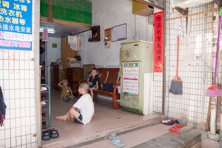 SHENZHEN, CHINA, 2011-07-24: Chinese kids in the hall of their house in poor disctrict of the cityのeditorial素材