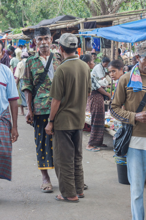 FLORES ISLAND, INDONESIA, 2012-04-18: men in traditional and military style clothes talking at the local street marketのeditorial素材