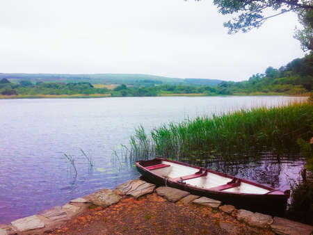 A boat moored at the edge of a lake in Southern Irelandの写真素材